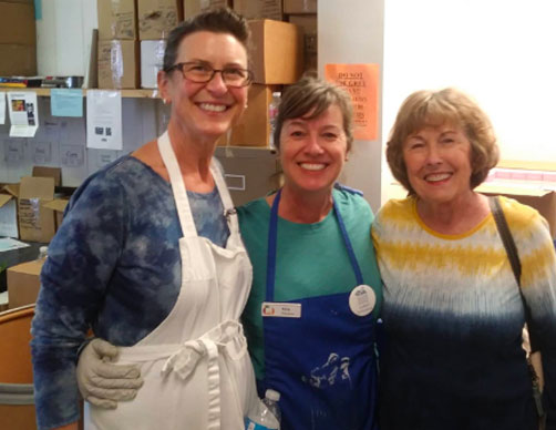 Three woman volunteers in a workroom